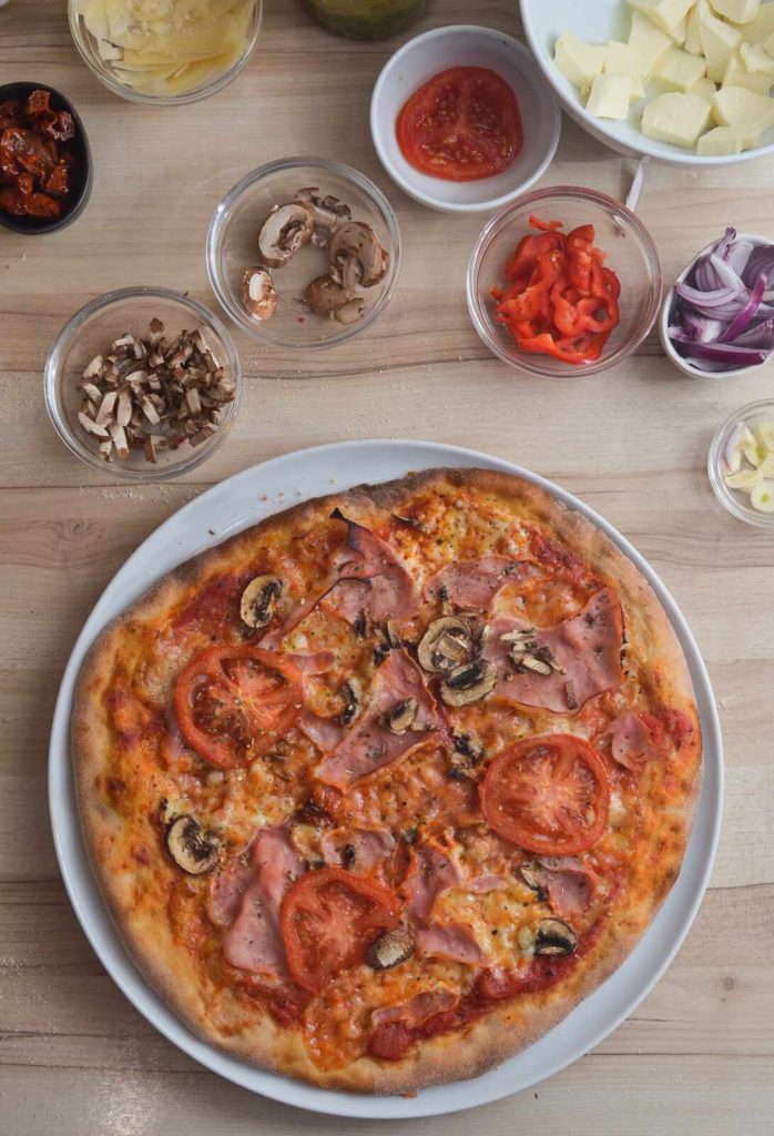 Selbstgemachte Pizza mit Schinken und Pilzen